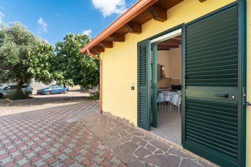 a house with a green door and a patio at Residence Sulcis 7 in Masainas