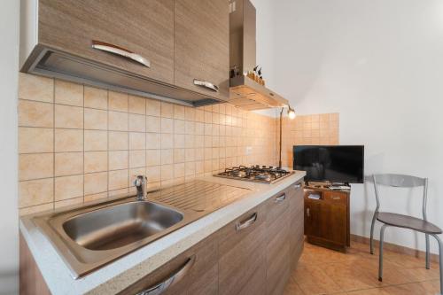 a kitchen with a sink and a stove at Residence Sulcis 7 in Masainas