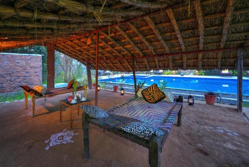 a large pavilion with a large swimming pool at ELIVAAS Bagh Serai, Ranthambore in Mokholī