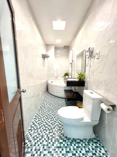 a bathroom with a toilet and a sink and a tub at Thanh Dat Resort in Can Tho
