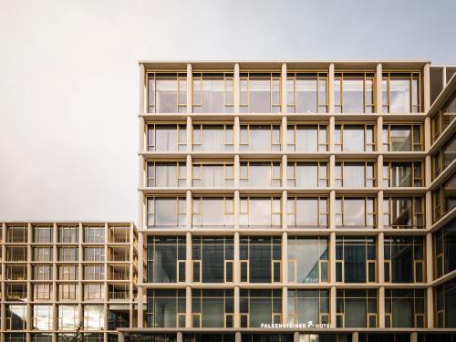a tall building with a lot of windows at Falkensteiner Hotel Bozen WaltherPark in Bolzano