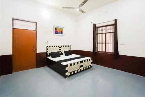 ein Zimmer mit einem Bett in der Mitte in der Unterkunft Hotel O Siddhi Vinayak Farms in Hāthras