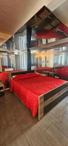 - une chambre avec un grand lit et des draps rouges dans l'établissement T2 Chambre Miroir jardin et parking privé Marseille, à Marseille