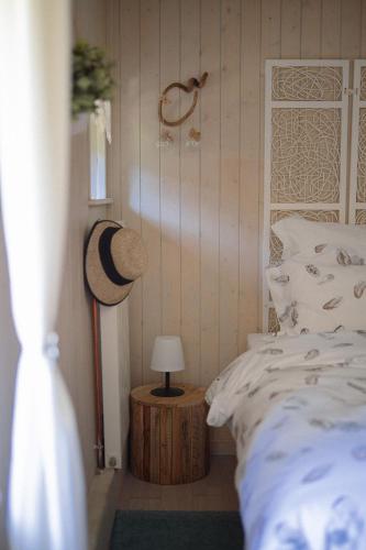 a bedroom with a bed and a hat on a table at Au Bois Dormant gîte 15 personnes in Lapoutroie