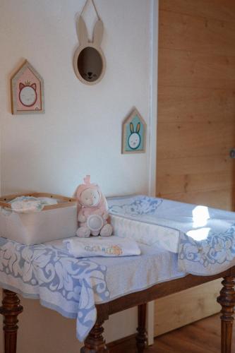 a baby bed with a box and a teddy bear at Au Bois Dormant gîte 15 personnes in Lapoutroie