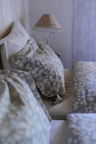a bed with two pillows and a lamp in a room at Au Bois Dormant gîte 15 personnes in Lapoutroie