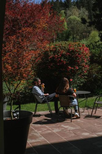 a man and woman sitting at a table in a park at Au Bois Dormant gîte 15 personnes in Lapoutroie