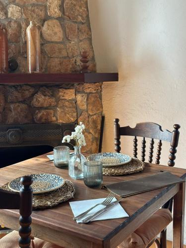 a wooden table with plates and utensils on it at Agroturismo Finca Son Pieras in Llucmajor