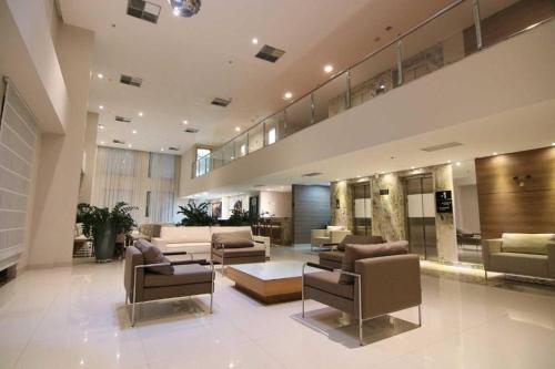 利尼亚雷斯Quarto duplo Samba Hotel Linhres的大楼内一个带沙发和椅子的大型大堂