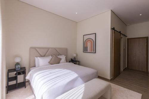 a bedroom with a large white bed and a closet at Ivory House Resort - Ophiolite in Hatta