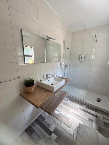 a white bathroom with a sink and a mirror at Quintinha Vale dos Pinheiros in Leiria