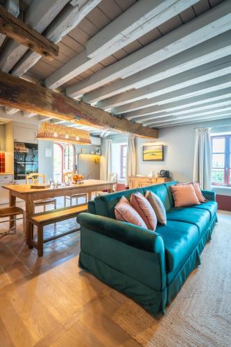 a living room with a blue couch and a table at Le Domaine de Richebourg - Pierres d'Histoire in Richebourg