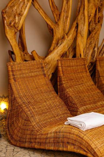 two wicker chairs sitting next to a tree at Hotel Mariver in Lido di Jesolo