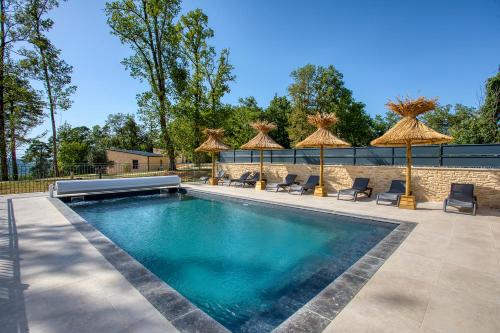 une piscine avec parasols et chaises et une piscine dans l'établissement Le domaine du Pech Eternel Sarlat, à Sarlat-la-Canéda