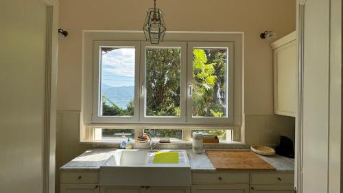 a kitchen with a sink and two windows at Villa Maria in Baveno