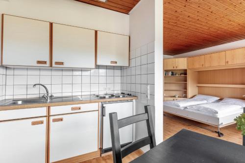 a kitchen with white cabinets and a bed in a room at Ferienwohnungen Kehrwieder in Todtnauberg