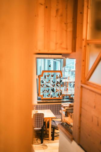 a table and chairs in a room with a window at Hotel Glemmtalerhof in Saalbach Hinterglemm