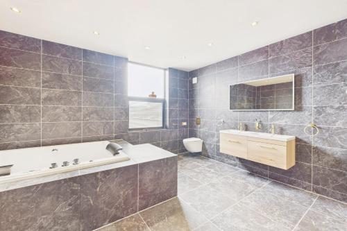 a bathroom with a tub and a sink at Host & Stay - Bellevue Luxe Rooms in Redcar