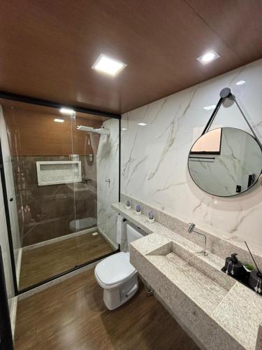 a bathroom with a shower and a toilet and a sink at Chalé Aconchego in Alto Caparao