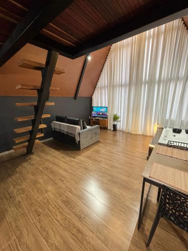a living room with a couch and a television at Chalé Aconchego in Alto Caparao