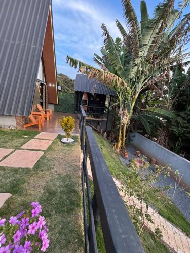 a fence in front of a house with a garden at Chalé Aconchego in Alto Caparao