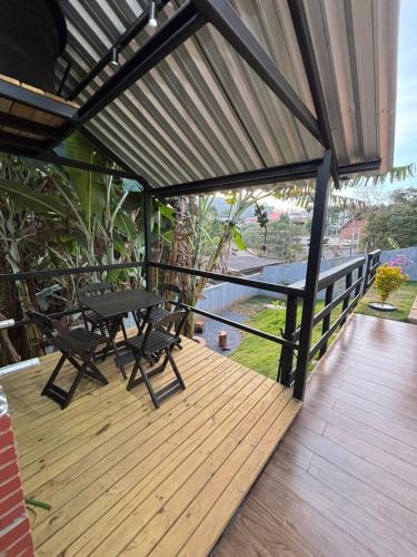 a wooden deck with a table and chairs on it at Chalé Aconchego in Alto Caparao