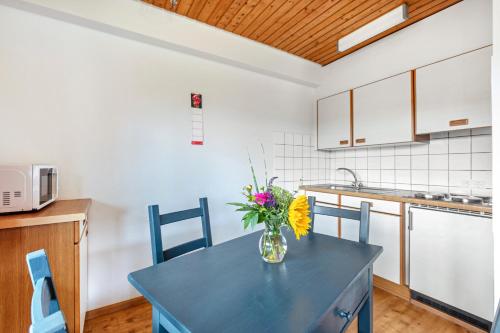a kitchen with a table with a vase of flowers on it at Ferienwohnungen Kehrwieder in Todtnauberg