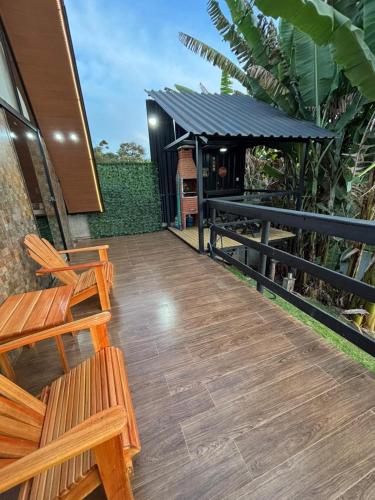 a wooden deck with two benches and a grill at Chalé Aconchego in Alto Caparao