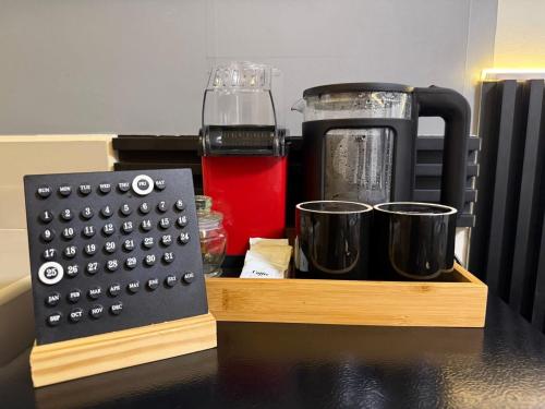 a wooden tray with a coffee maker and cups at Condo in Fairview SM Terraces Cozy Netflix in Manila