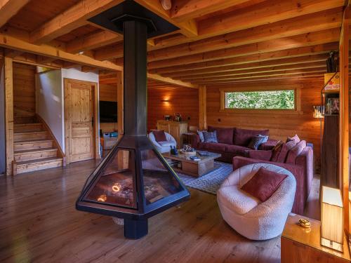 a living room with a fireplace in a cabin at Chalet LE VAL NESS in La Côte dʼArbroz