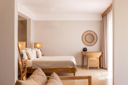 a bedroom with two beds and a table and a mirror at Kaskazi Hotel Zanzibar in Jambiani