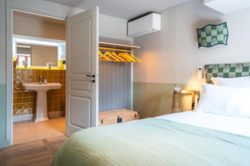 a bedroom with a bed and a sink at Le Domaine de Richebourg - Pierres d'Histoire in Richebourg
