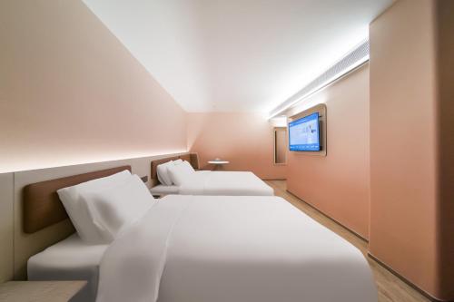 a hotel room with two beds and a tv at Hanting Hotel Beijing Fangshan Changyang Aerospace City Electronic Technology Park in Beijing