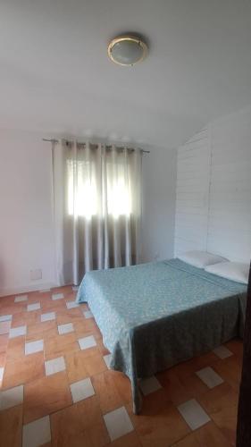a bedroom with a bed and a window and a wooden floor at petit esperantza in Saint-Pée-sur-Nivelle