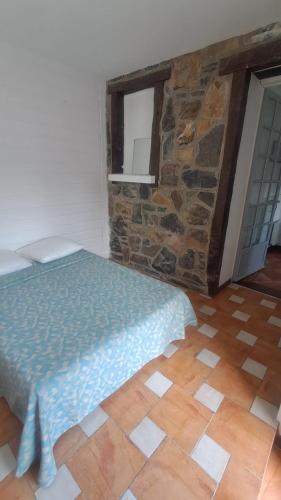 a bedroom with a bed and a stone wall at petit esperantza in Saint-Pée-sur-Nivelle