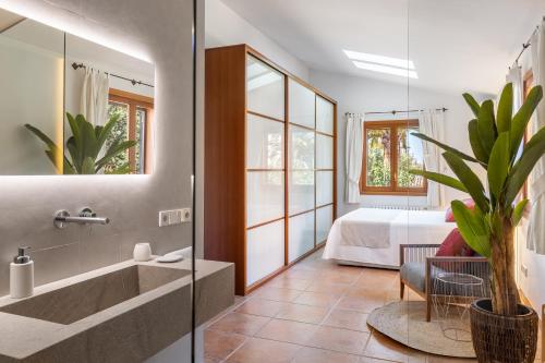 Un baño con bañera y un dormitorio con cama. en Sembat de Mar, en Cala Millor