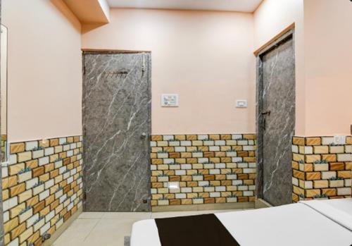 a bathroom with two sliding doors in a room at Hotel Sana a family-friendly guest house in Kolkata