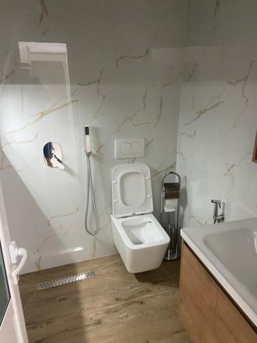 une salle de bain avec toilettes et un téléphone mural dans l'établissement Vila Balliu, à Buçimas