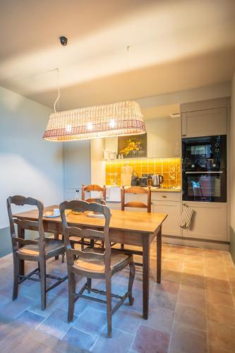 a dining room with a wooden table and chairs at Le Domaine de Richebourg - Pierres d'Histoire in Richebourg