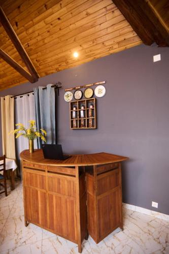 a wooden counter with clocks on a blue wall at Cléo Hôtel-Restaurant in Fianarantsoa