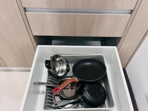 a stove top with pots and pans in a drawer at Colombo, Trizen Luxury Apartments, Sri Lanka in Colombo