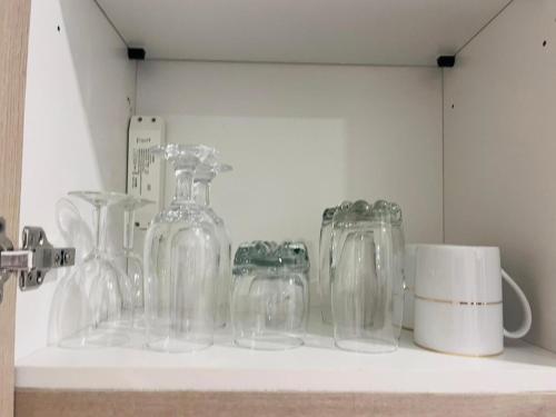a shelf with clear glass jars and a mug at Colombo, Trizen Luxury Apartments, Sri Lanka in Colombo