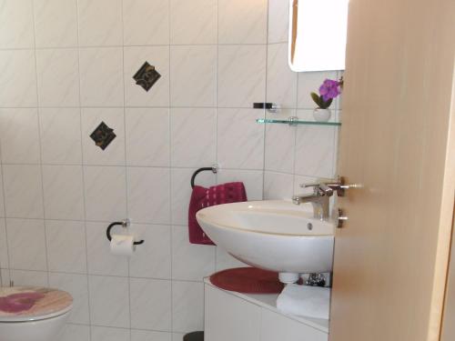 a white bathroom with a sink and a toilet at Haus Obere Weinburg in Radolfzell am Bodensee
