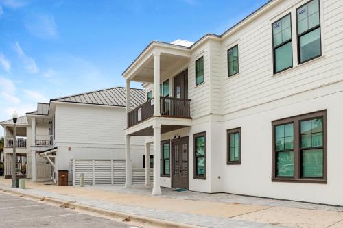 a white house with a balcony on a street at Highball Heaven by Pristine Properties Vacation Rentals in Port Saint Joe