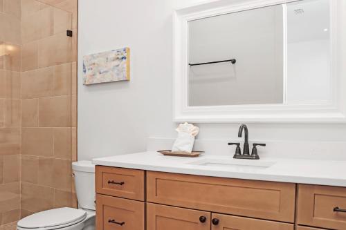 a bathroom with a sink and a toilet and a mirror at Highball Heaven by Pristine Properties Vacation Rentals in Port Saint Joe