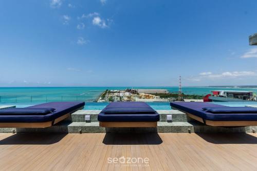 two beds on a deck with the ocean in the background at NWTs - Estúdios em Prédio com Vista Mar in Maceió