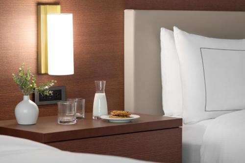 a bedroom with a table with a plate of food on a bed at DoubleTree by Hilton Bloomington Minneapolis South in Bloomington