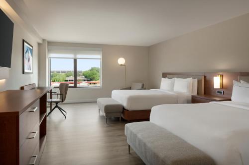 a hotel room with two beds and a desk at DoubleTree by Hilton Bloomington Minneapolis South in Bloomington