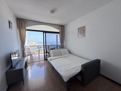 una camera da letto con un letto e vista sull'oceano di Guayarmina a Puerto Rico de Gran Canaria