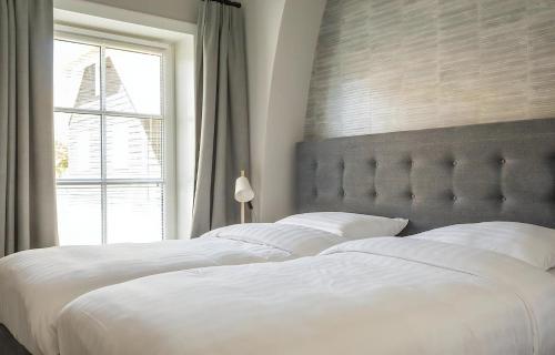 a bedroom with a large white bed with a window at G-21 Bouwlust in De Cocksdorp